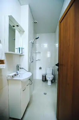 a white bathroom with a sink and a toilet at Princess Apartment in Sandanski