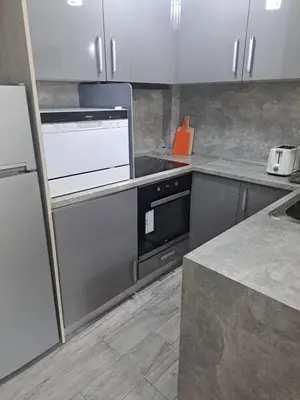 a kitchen with white cabinets and a stove at Удобство - 2 in Petrich