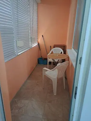 a small table and chairs in a room with a window at Удобство - 2 in Petrich