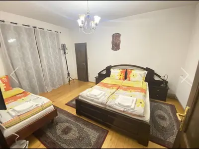 a bedroom with two beds and a chandelier at Вила СевРич in Sarnitsa