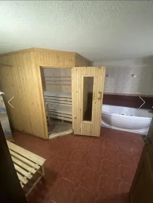 a room with a bath tub and a wooden cabinet at Вила СевРич in Sarnitsa
