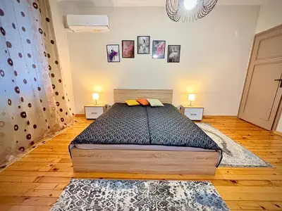 a bedroom with a large bed with two night stands at просторен и уютен двустаен в Долен Лозенец - кварталът на артистите in Sofia