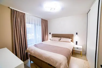 a bedroom with a large bed and a window at Apartments Polejanov in Razlog