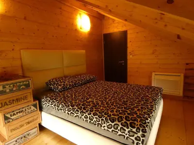 a bedroom with a bed in a log cabin at Стилни и Луксозни Вили за разпускане in Malo Buchino