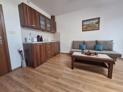 a living room with a couch and a table at Rila Park by the Slopes in Borovets
