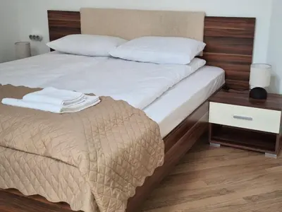 a bedroom with a large bed and a night stand at Rila Park by the Slopes in Borovets
