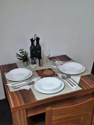 a wooden table with plates and wine glasses on it at Rila Park by the Slopes in Borovets