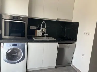 a kitchen with a washing machine and a microwave at Ira 28 in Sandanski