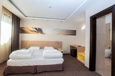 a bedroom with two beds and a painting on the wall at Therma Vitae - Профилакториум Огняново in Ognyanovo
