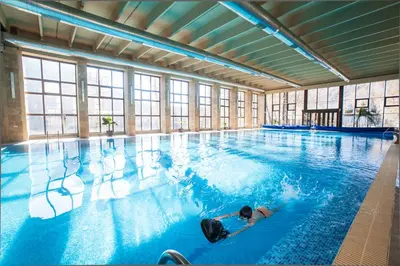 a person swimming in a large swimming pool at Therma Vitae - Профилакториум Огняново in Ognyanovo