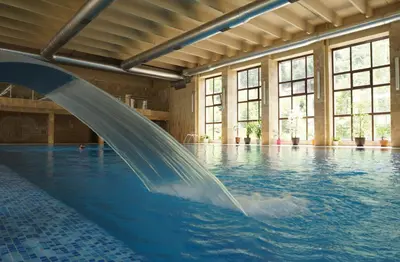 a pool with a water slide in a swimming pool at Therma Vitae - Профилакториум Огняново in Ognyanovo
