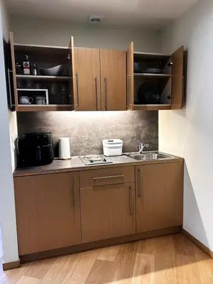 a kitchen with wooden cabinets and a sink at Beauty&Travel Apartment Borovets in Borovets