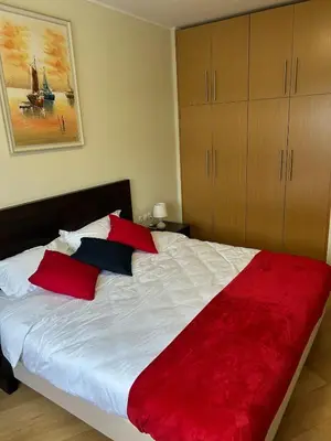 a bedroom with a large bed with red and black pillows at Beauty&Travel Apartment Borovets in Borovets