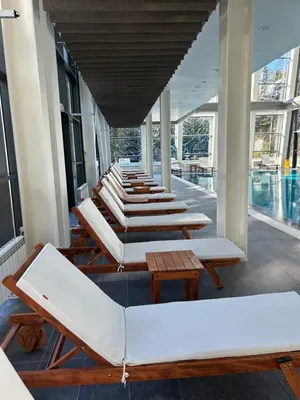 a row of chaise lounge chairs and a pool at Beauty&Travel Apartment Borovets in Borovets