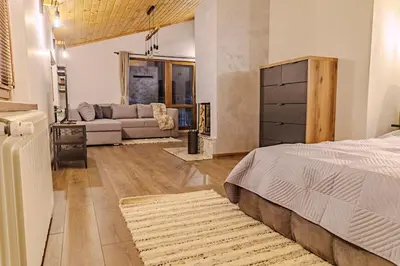 a bedroom with a bed and a living room at Mountain studio Govedartsi in Govedartsi