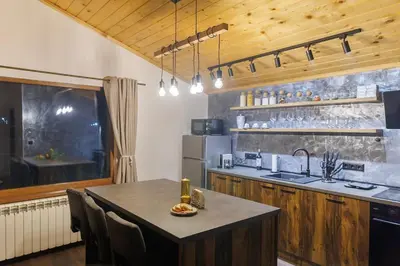 a kitchen with a table with chairs and a refrigerator at Mountain studio Govedartsi in Govedartsi