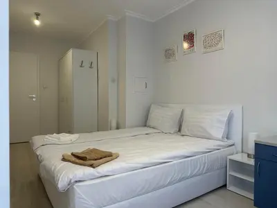 a bedroom with a white bed with a towel on it at White Pearl Apartment - Top Location, Bright & Spacious, Newly Renovated in Sofia