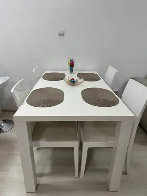 a white table with four chairs and a vase on it at White Pearl Apartment - Top Location, Bright & Spacious, Newly Renovated in Sofia
