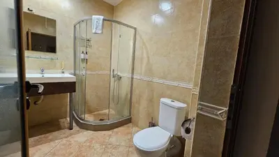 a bathroom with a shower and a toilet and a sink at Hotel Izvorat Arda - Хотел Изворът Арда in Arda