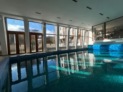 a large swimming pool in a building with windows at Ski-in Flat Next to Ski Road at Mountain View in Bansko