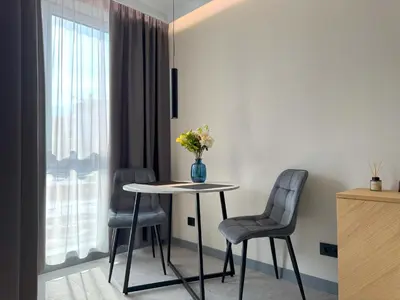 a room with a table and two chairs and a vase with flowers at Eleve Residences Sofia in Sofia