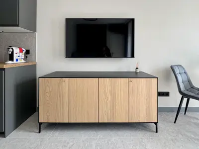 a tv on top of a wooden cabinet in a room at Eleve Residences Sofia in Sofia