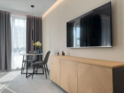a living room with a television on a wall at Eleve Residences Sofia in Sofia
