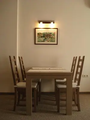 a dining room table with chairs and a picture on the wall at Granat next to Ski Lift by BookVillaBG in Bansko