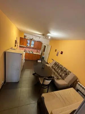 a living room with a couch and a table and a kitchen at Ritz in Sofia