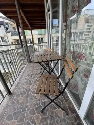 a balcony with a wooden table and two benches at Ritz in Sofia