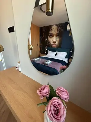a mirror in a room with a bed and pink roses at Blue Iris, 2BR, Stunning Views, Jacuzzi and Workspace in Sofia