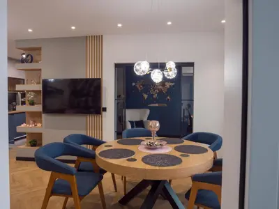 a dining room with a table and blue chairs at Blue Iris, 2BR, Stunning Views, Jacuzzi and Workspace in Sofia
