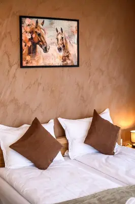 a bedroom with a painting of horses on the wall at DreamAparts in Velingrad