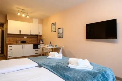 a room with two towels on a bed with a kitchen at DreamAparts in Velingrad