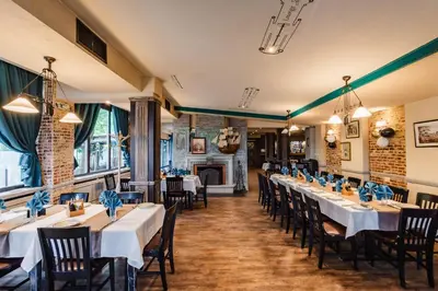 a dining room with tables and chairs and a fireplace at Vintage H&R St Anna in Sofia