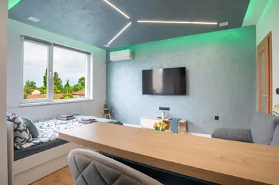 a living room with a table and a flat screen tv at Studio Sapphire in Sofia