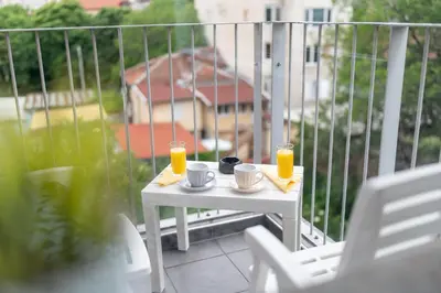 a white table with two cups and two glasses of orange juice at Studio Sapphire in Sofia