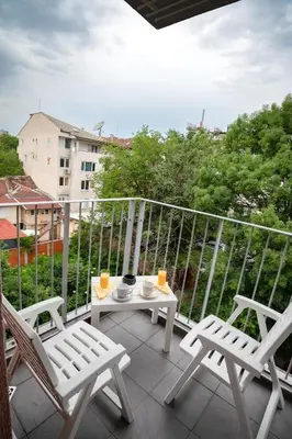 a balcony with two chairs and a table with drinks on it at Studio Sapphire in Sofia