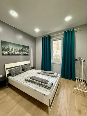 a bedroom with a large bed with blue curtains at The Rainbow 10 in Sofia