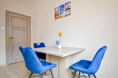 a dining room with blue chairs and a table at Orchidea City Centre 1BDR by Flat Mаnager in Sofia