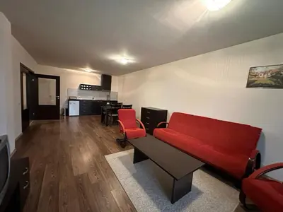 a living room with a red couch and red chairs at Bansko Royal Towers in Bansko