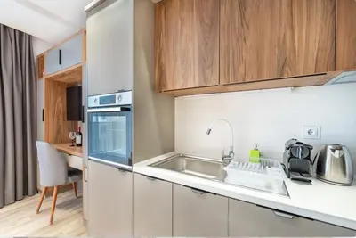 a kitchen with white cabinets and a sink at Апартхотел Сенатор Пловдив Self check-in in Plovdiv