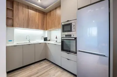a kitchen with white cabinets and a refrigerator at Апартхотел Сенатор Пловдив Self check-in in Plovdiv
