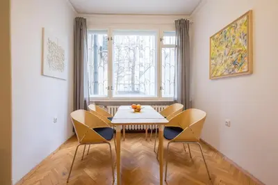 a dining room with a table and chairs and a window at THE GOOD PLACE - historical center, unique in Sofia