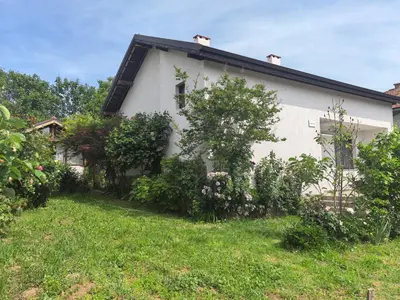 a white house with some bushes in front of it at Харизма in Hisarya