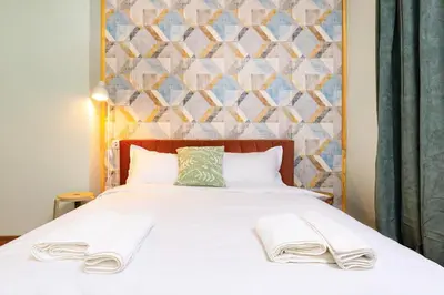 a bedroom with a bed with two towels on it at HeBrOs Park Apartment Next to Kapana 2BR in Plovdiv