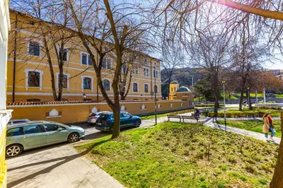 a building with cars parked in front of a street at HeBrOs Park Apartment Next to Kapana 2BR in Plovdiv