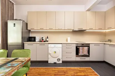 a kitchen with white cabinets and a table at HeBrOs Park Apartment Next to Kapana 2BR in Plovdiv