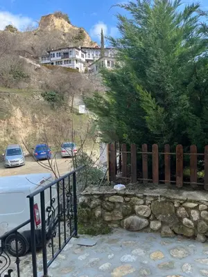 a fence next to a parking lot with a house at Apаrtment Melnik home in Melnik