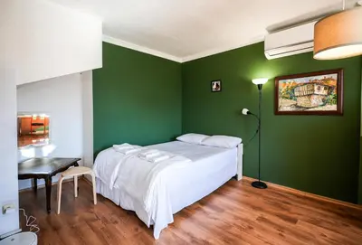 a green bedroom with a bed and a table at 2BDR Yavorov apartment in Sofia